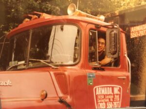 Chancellor Garcia driving a red truck as a young man